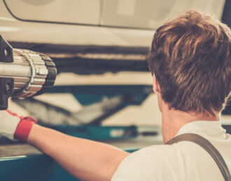 Mechanic Performing Wheel Alignment Services
