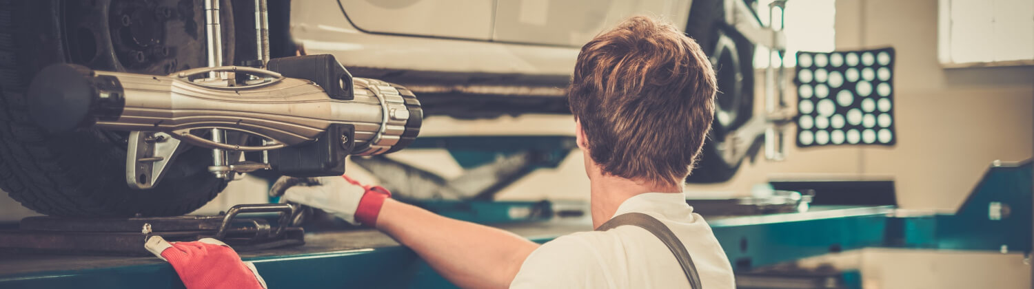 Mechanic Performing Wheel Alignment Services